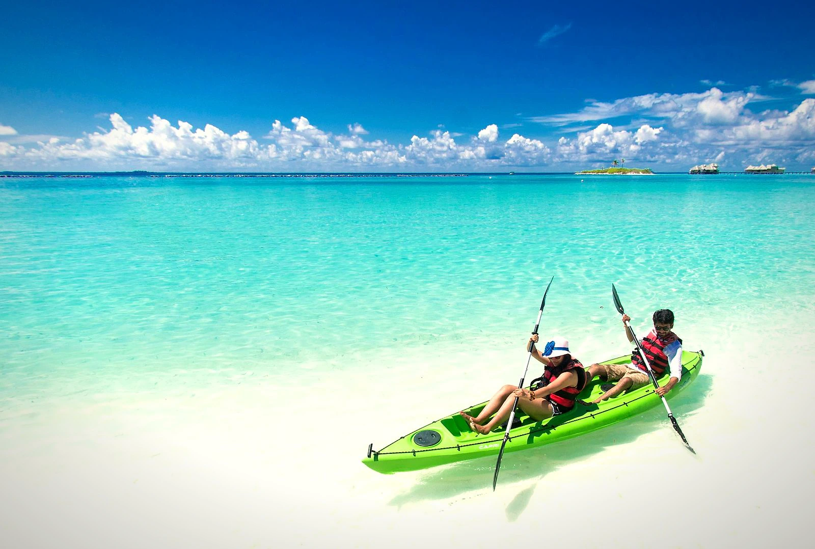 Two people kayaking in clear turquoise water near the Hong Islands