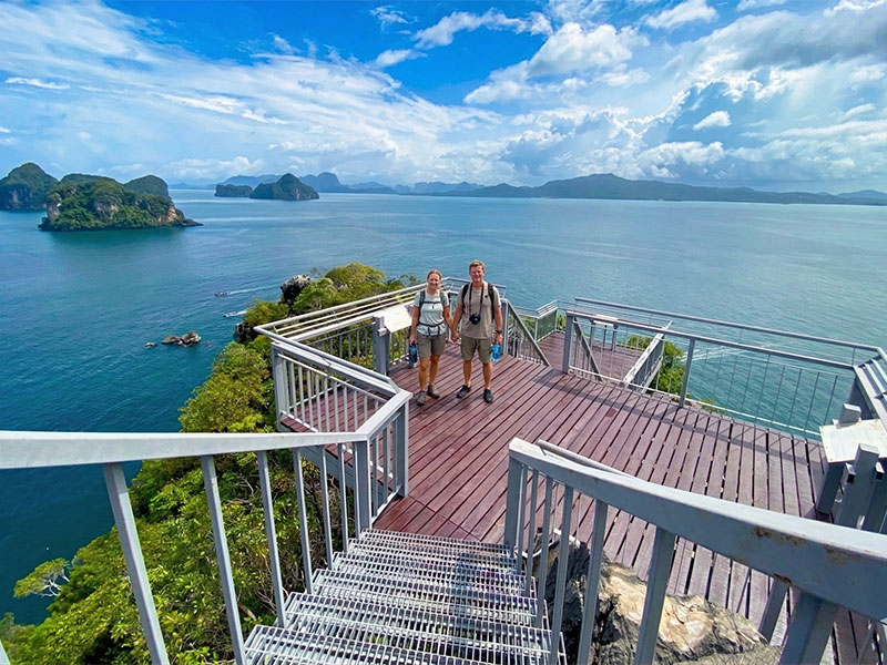 Two visitors on the Koh Hong 360 viewpoint platform looking out over Phang Nga Bay and the limestone islands